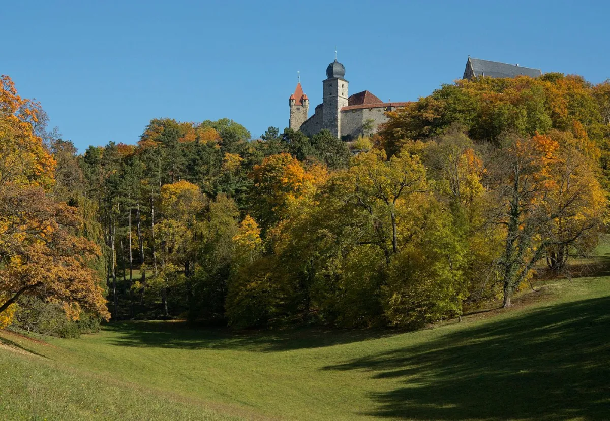 Burg auf einem Hügel mit Herbstbäumen