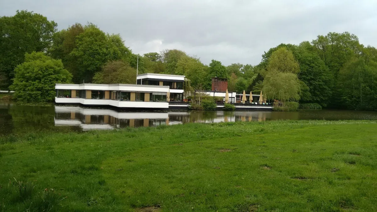 Modernes Gebäude am See mit Bäumen