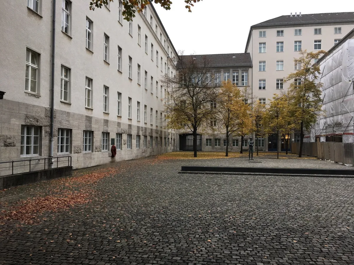 Innenhof mit Kopfsteinpflaster und Bäumen im Herbst.