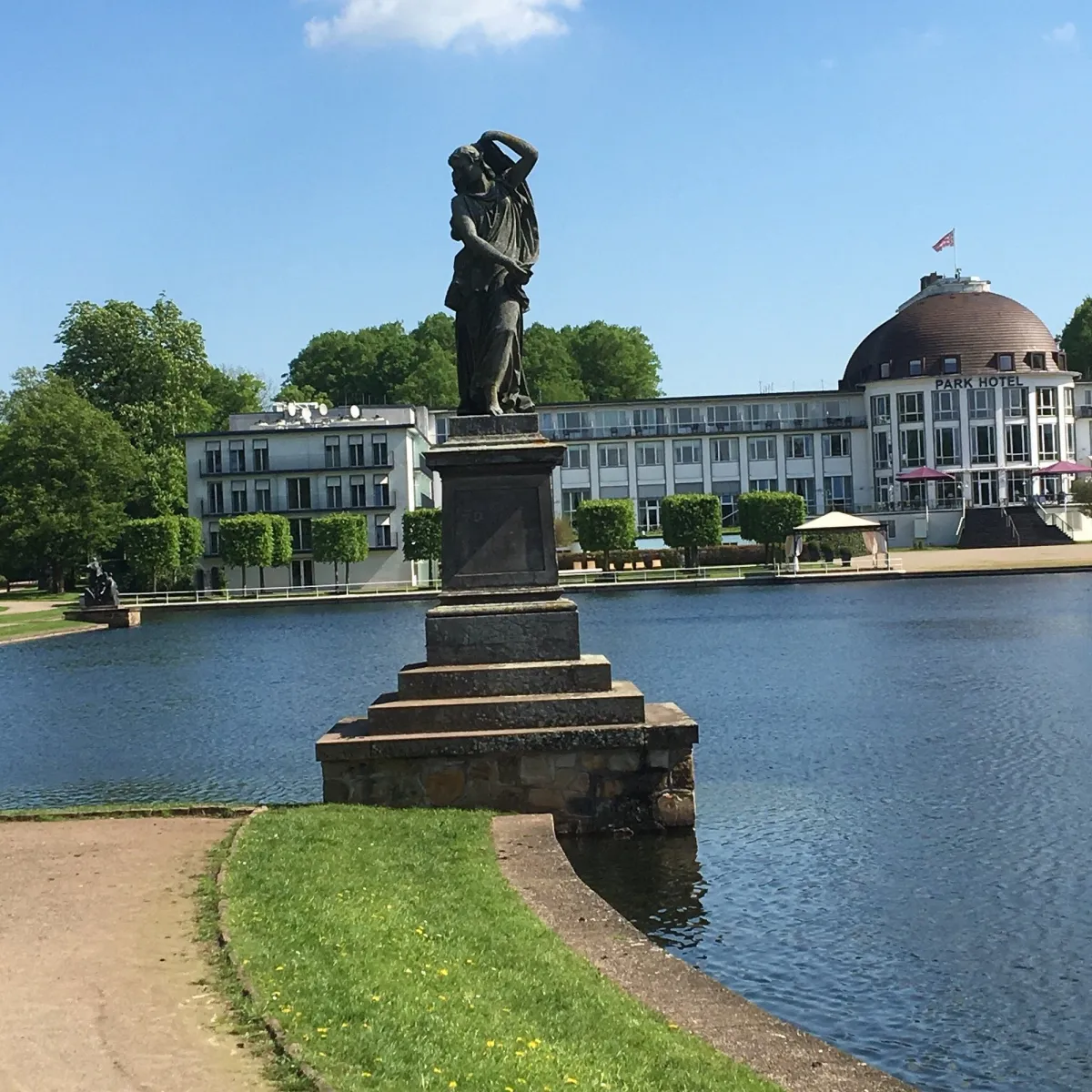 Statue am See vor einem Hotel.