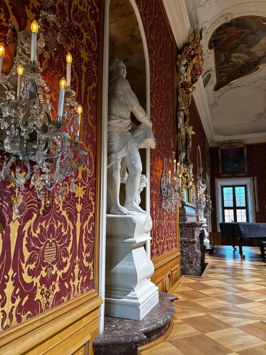 Barockraum mit Statue und Kronleuchtern