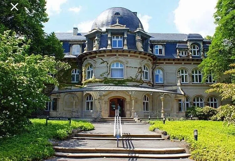 Historisches Gebäude mit Kuppeldach und Garten