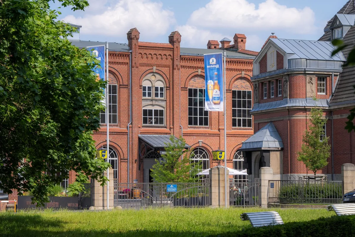 Backsteingebäude mit Fahnen und grünem Vordergrund