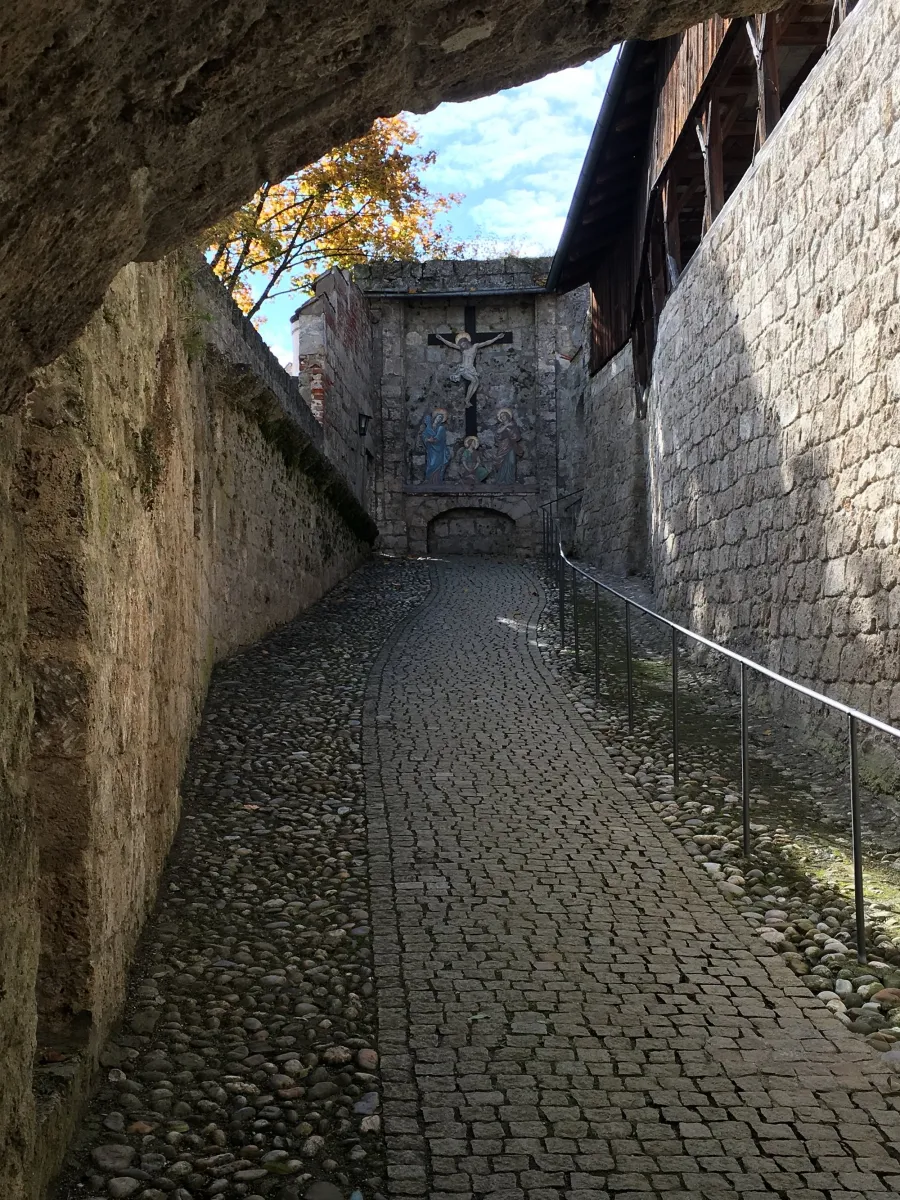 Gepflasterter Weg zwischen alten Steinmauern mit Fresko.