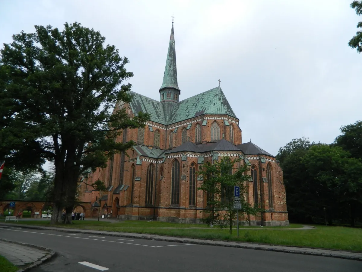 Backsteinkirche mit grünem Dach und Turm