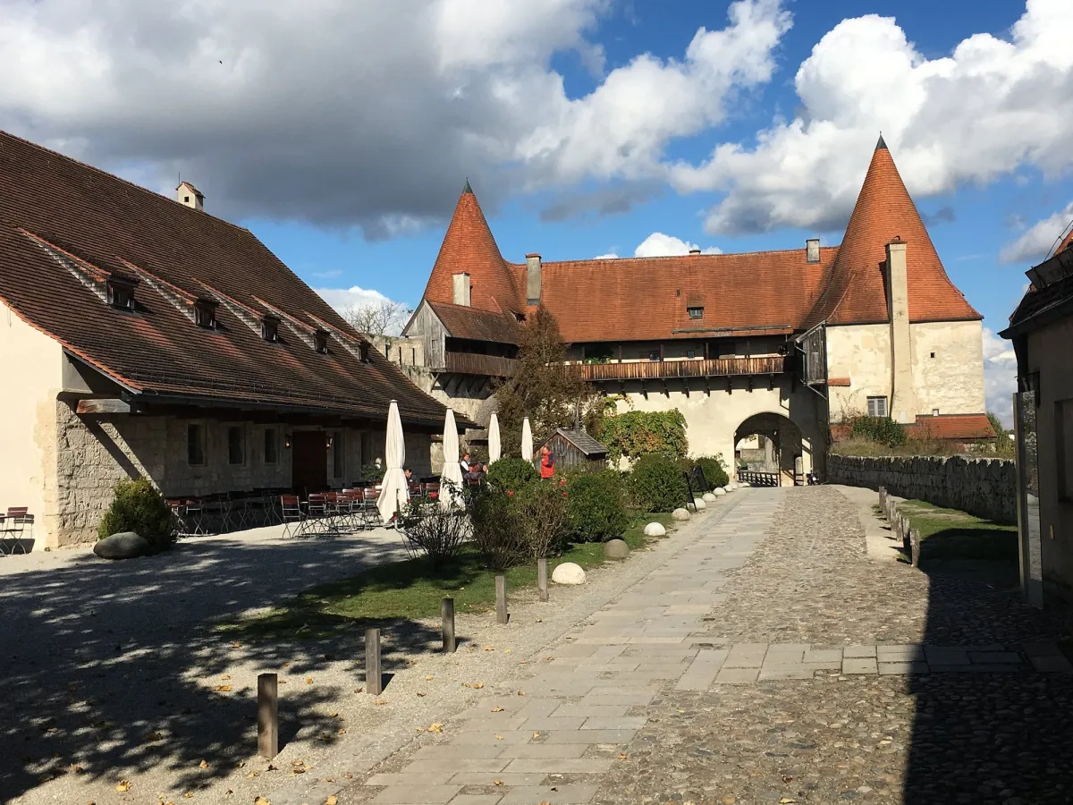 Historische Burg mit roten Dächern und Innenhof.