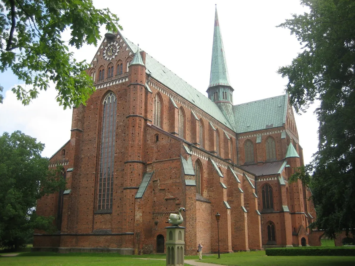 Backsteinkirche mit Turm und grünen Bäumen