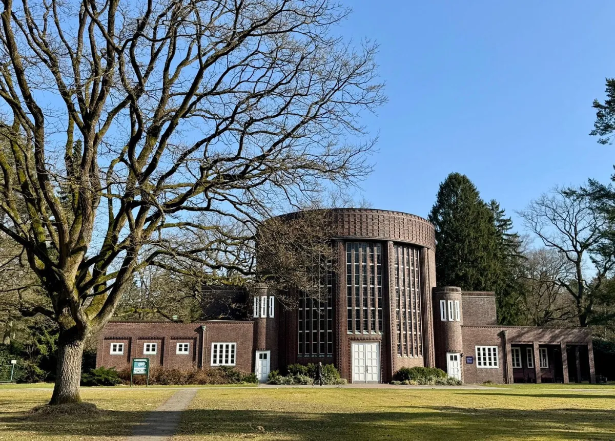 Backsteingebäude mit großen Fenstern und Bäumen