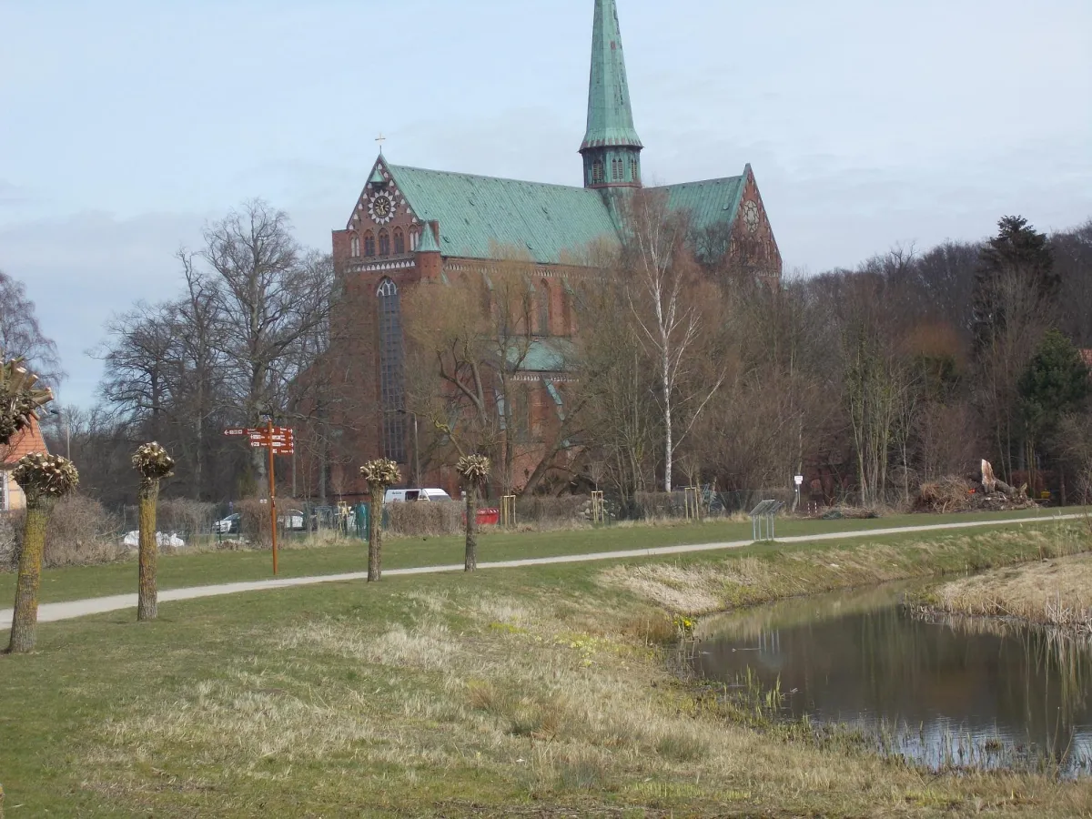 Backsteinkirche mit grünem Dach und Turm