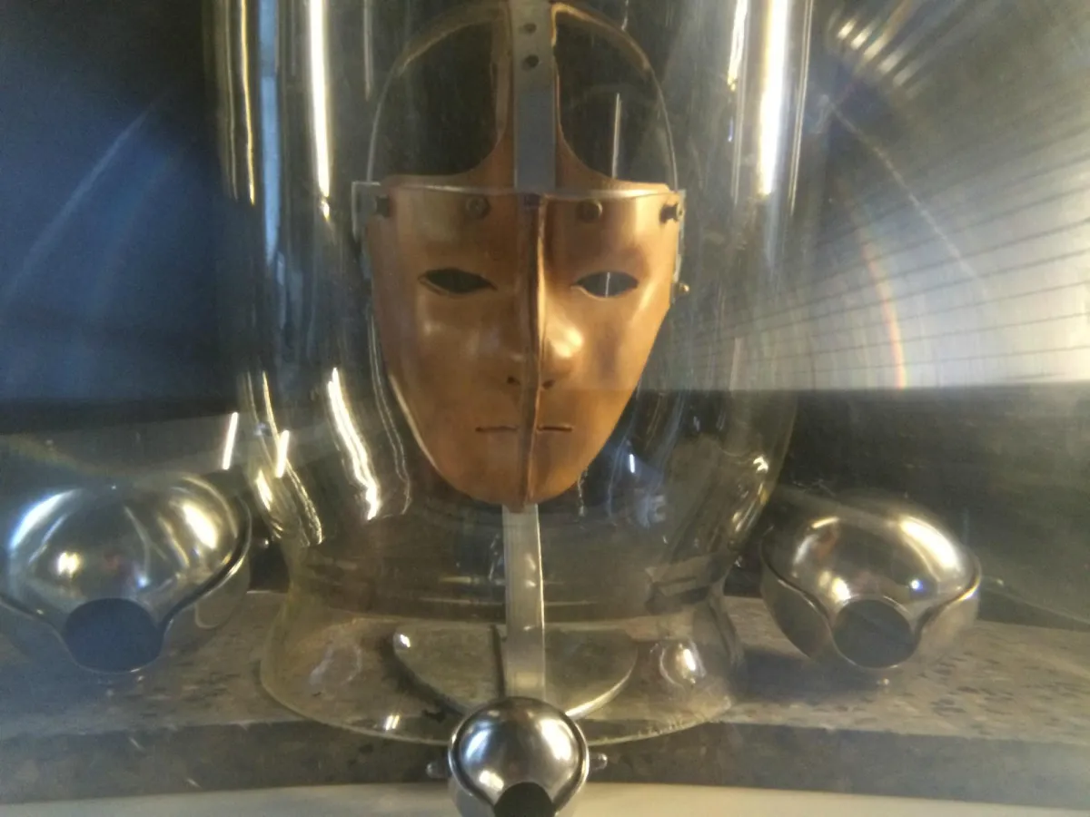Metallmaske hinter Glas