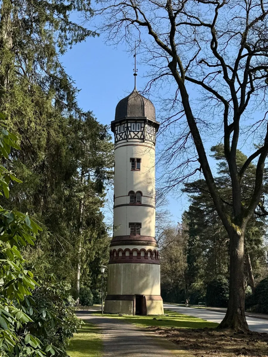 Historischer Turm im Park mit Bäumen