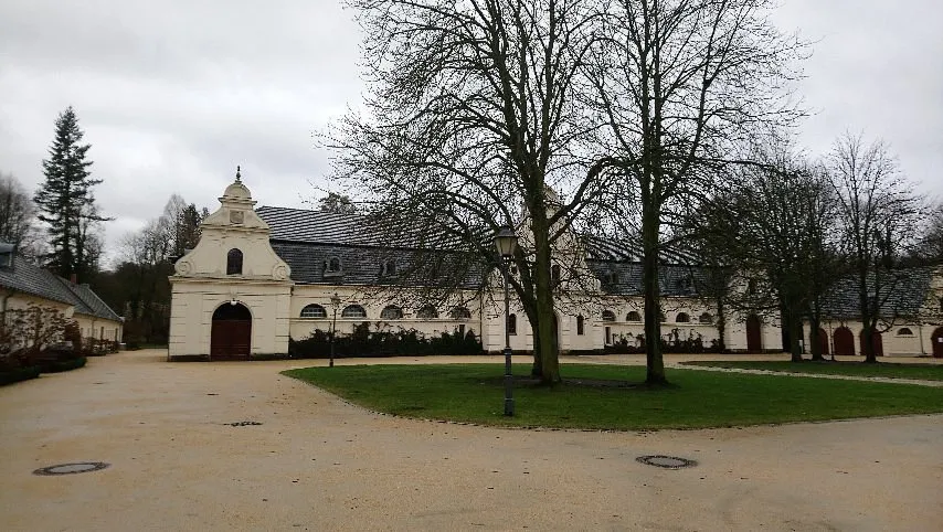 Historisches Gebäude mit Bäumen im Vordergrund.
