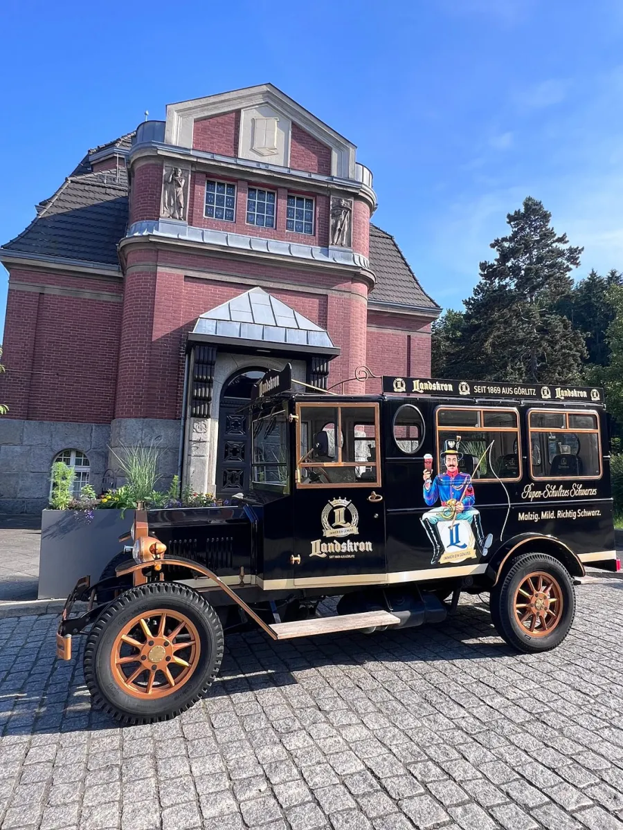 Historisches Fahrzeug vor einem Backsteingebäude