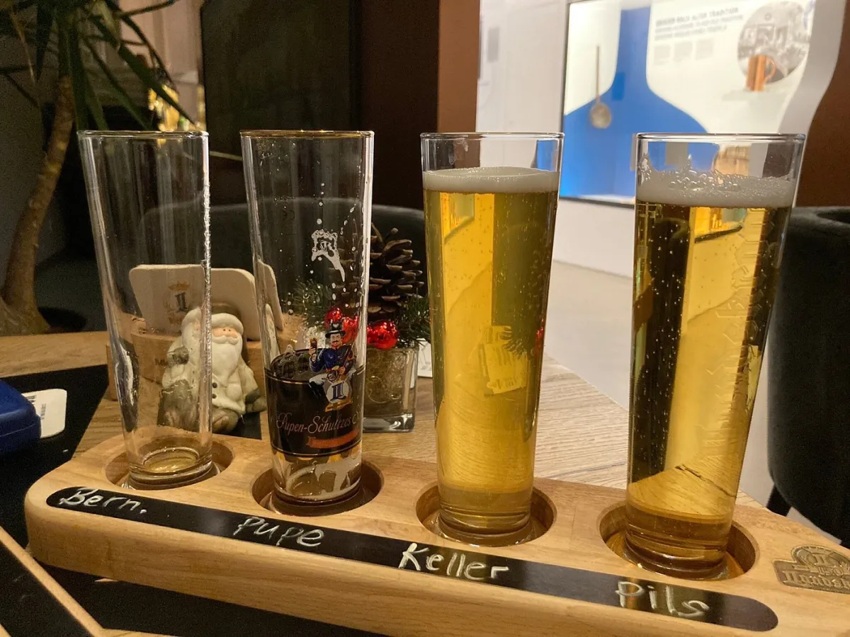 Vier Biergläser in einem Holzträger.