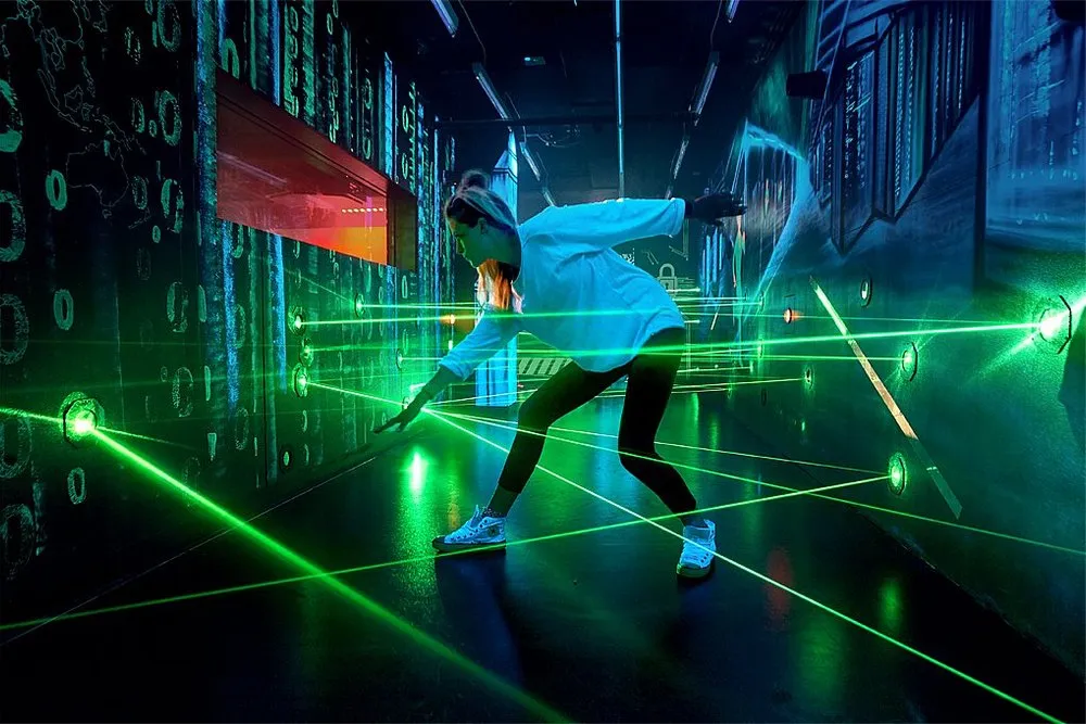 Person schleicht durch Laserparcours.