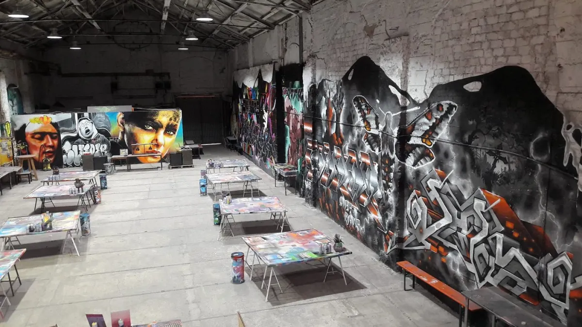 Innenansicht einer Halle mit Graffiti an den Wänden.