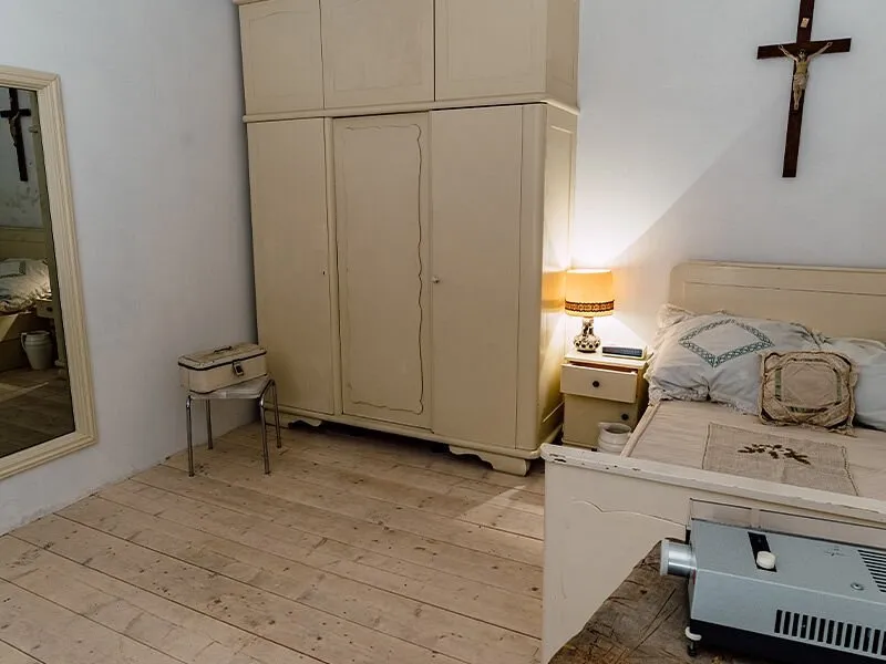 Ein einfach eingerichtetes Schlafzimmer mit Schrank und Bett.