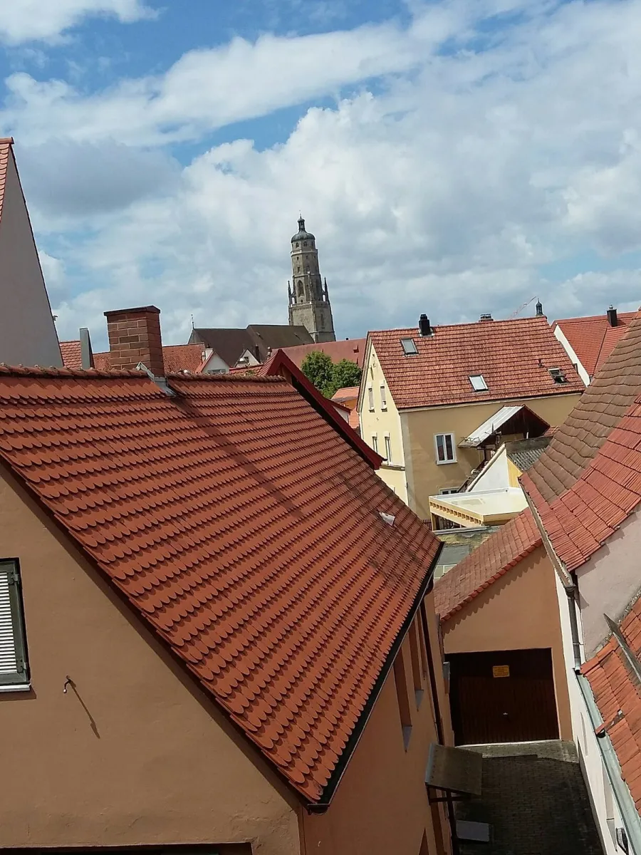 Blick auf rote Ziegeldächer und einen Kirchturm