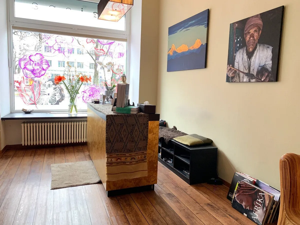 Innenraum eines stilvollen Salons mit Kunstwerken und Blumen.