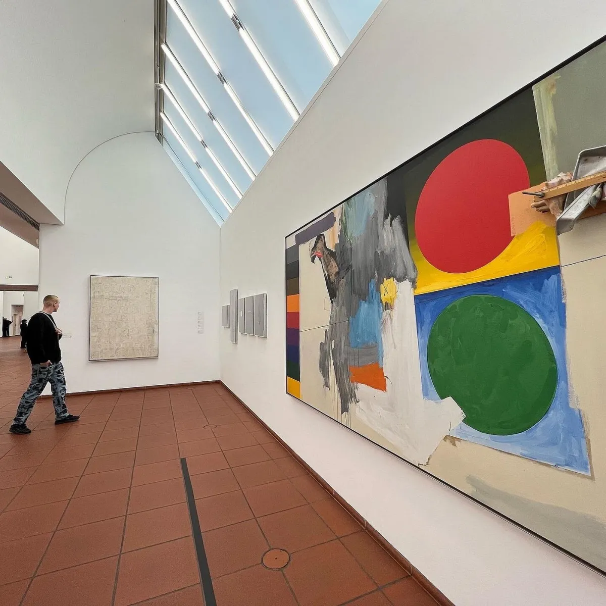 Person in einer Kunstgalerie mit abstrakten Gemälden.