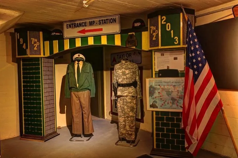 Militäruniformen und US-Flagge in Ausstellung.