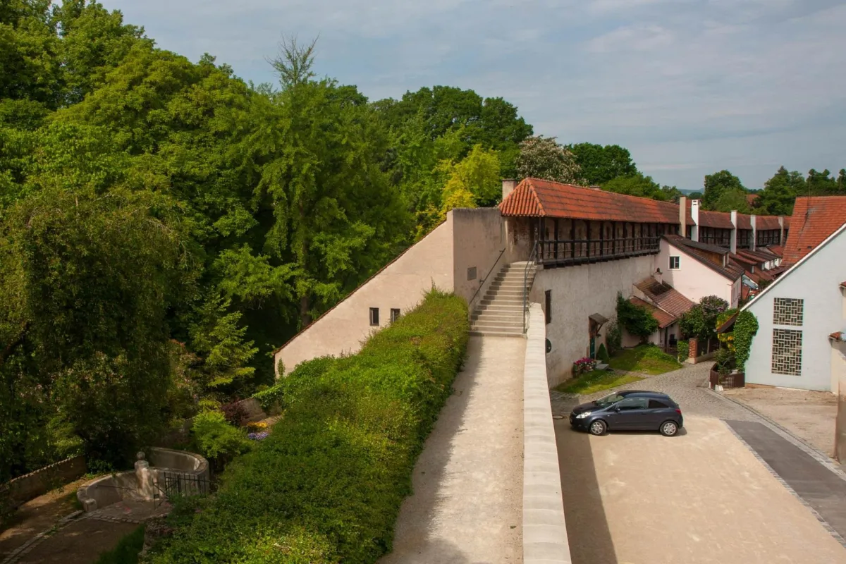 Historische Stadtmauer mit Treppe und Auto.