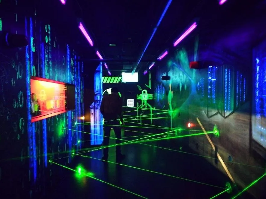 Person in einem Raum mit grünen Laserstrahlen