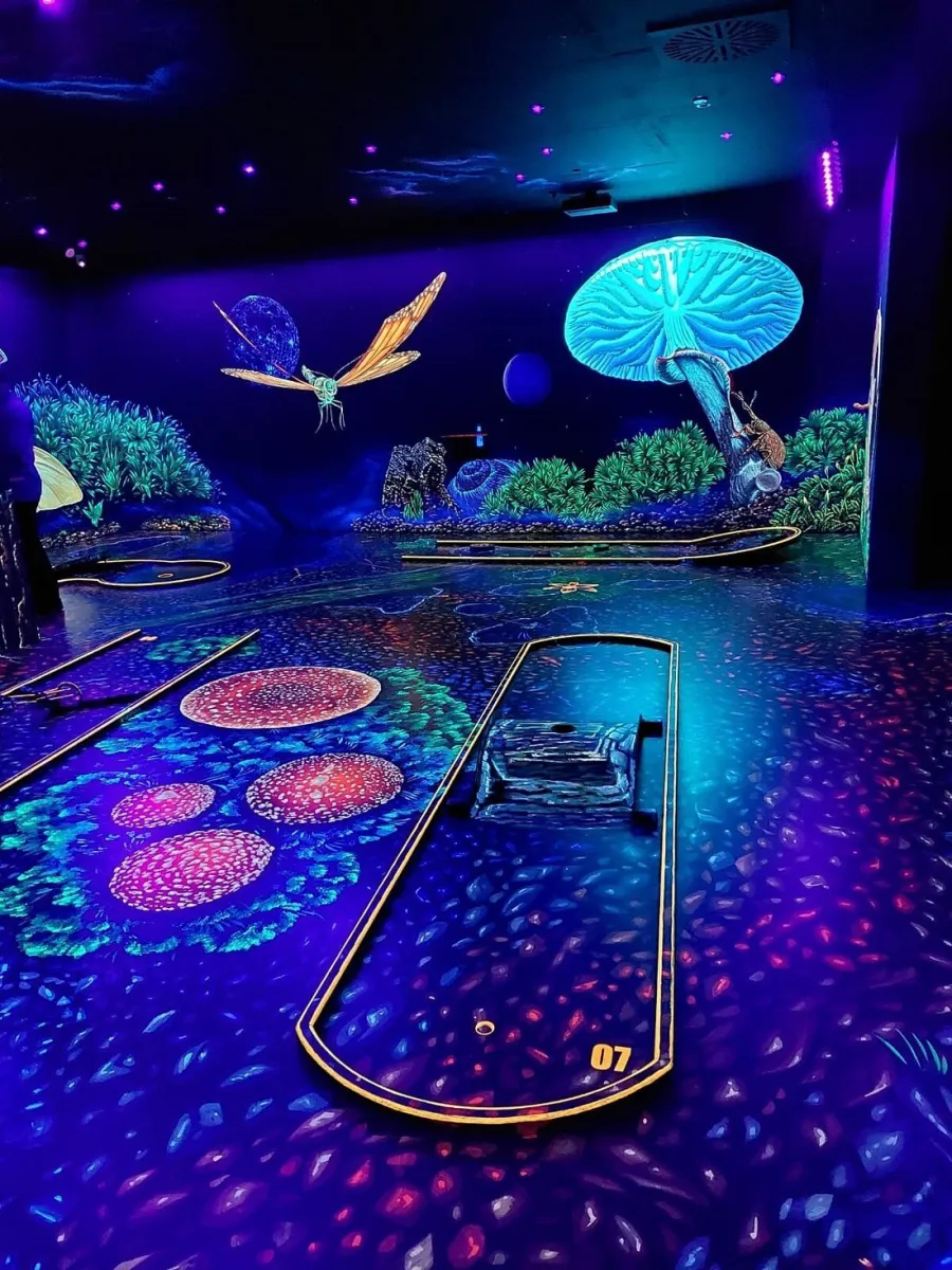 Leuchtendes Minigolf mit neonfarbenen Motiven.