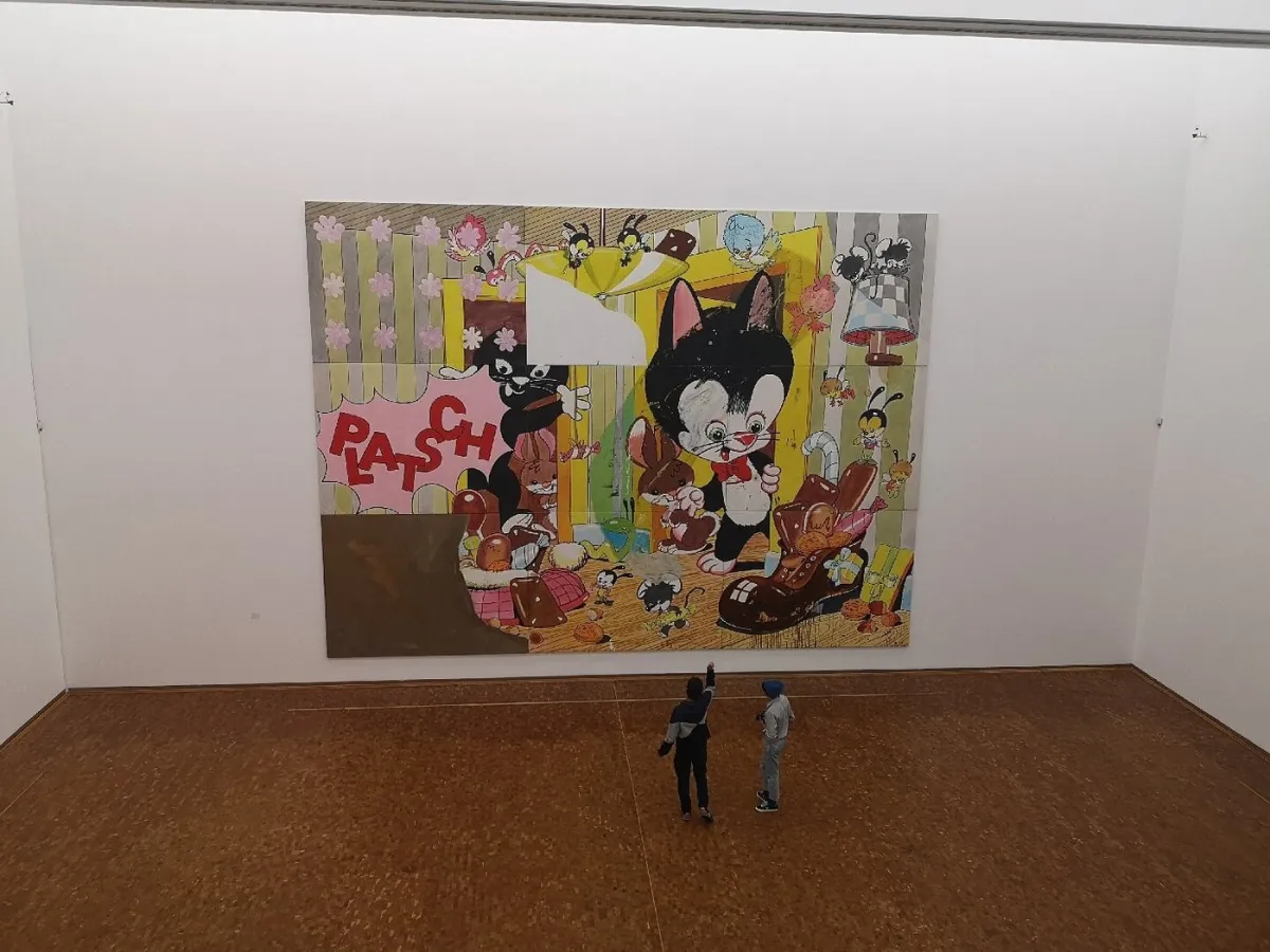 Zwei Personen betrachten ein großes Gemälde mit Comicfiguren.