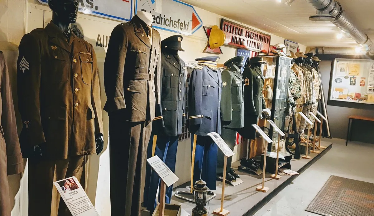 Reihe von Militäruniformen auf Schaufensterpuppen.