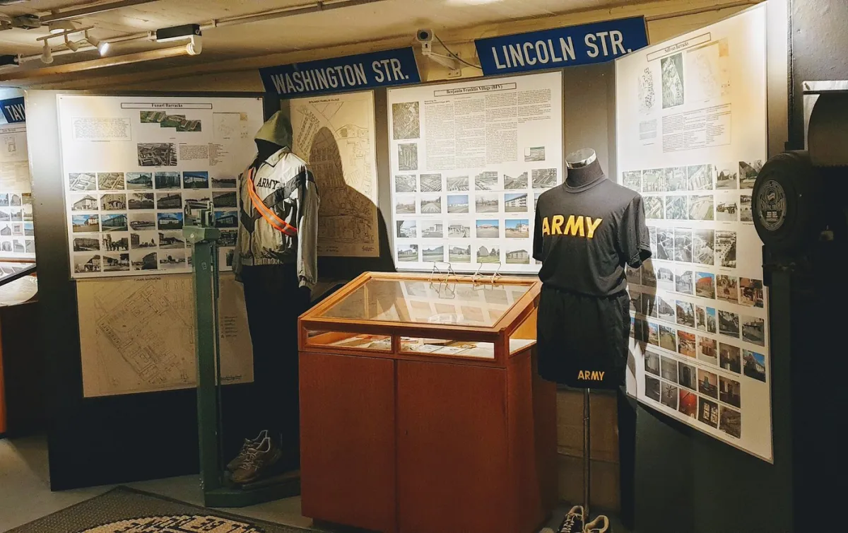 Museumsausstellung mit Armeeuniformen und Infotafeln.