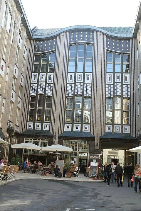 Innenhof mit verzierten Fassaden und Cafés.