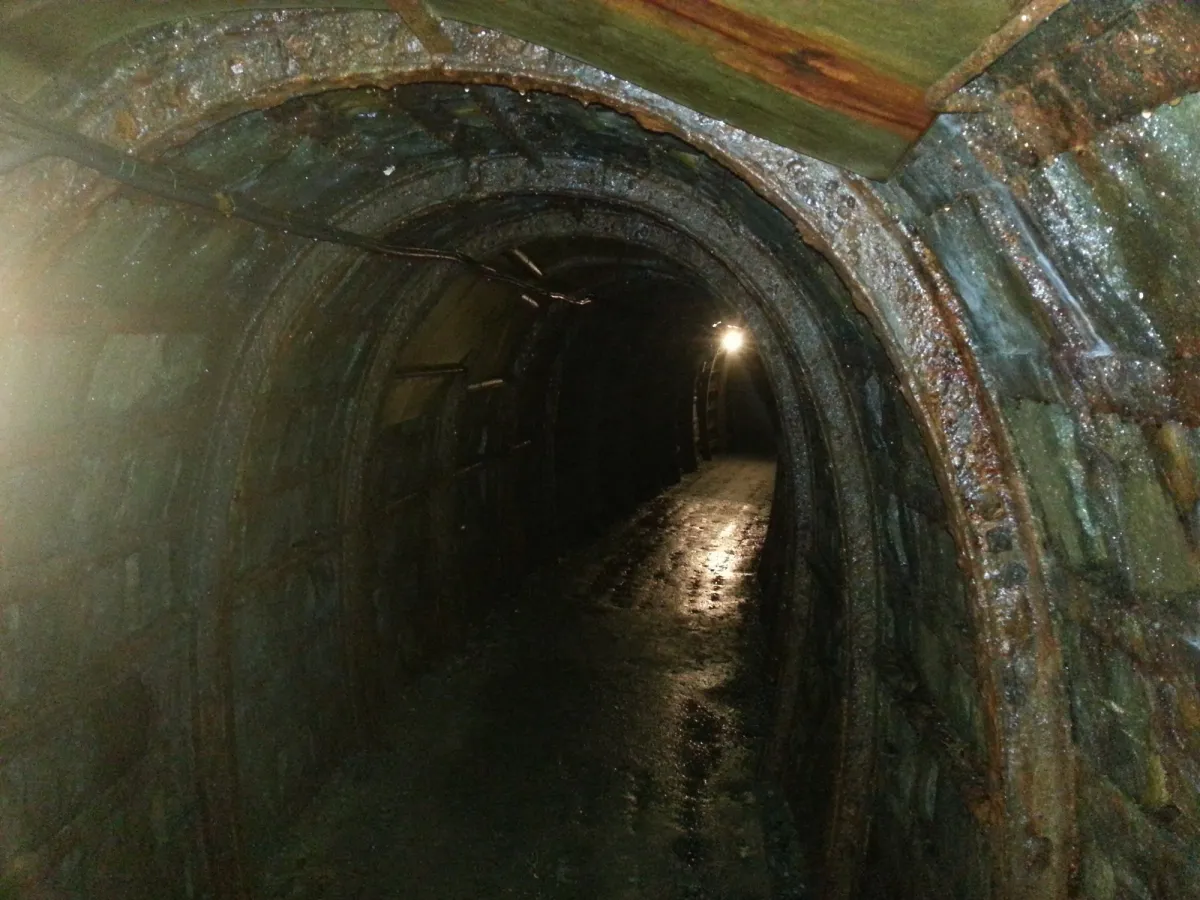 Dunkler Tunnel mit beleuchtetem Ende