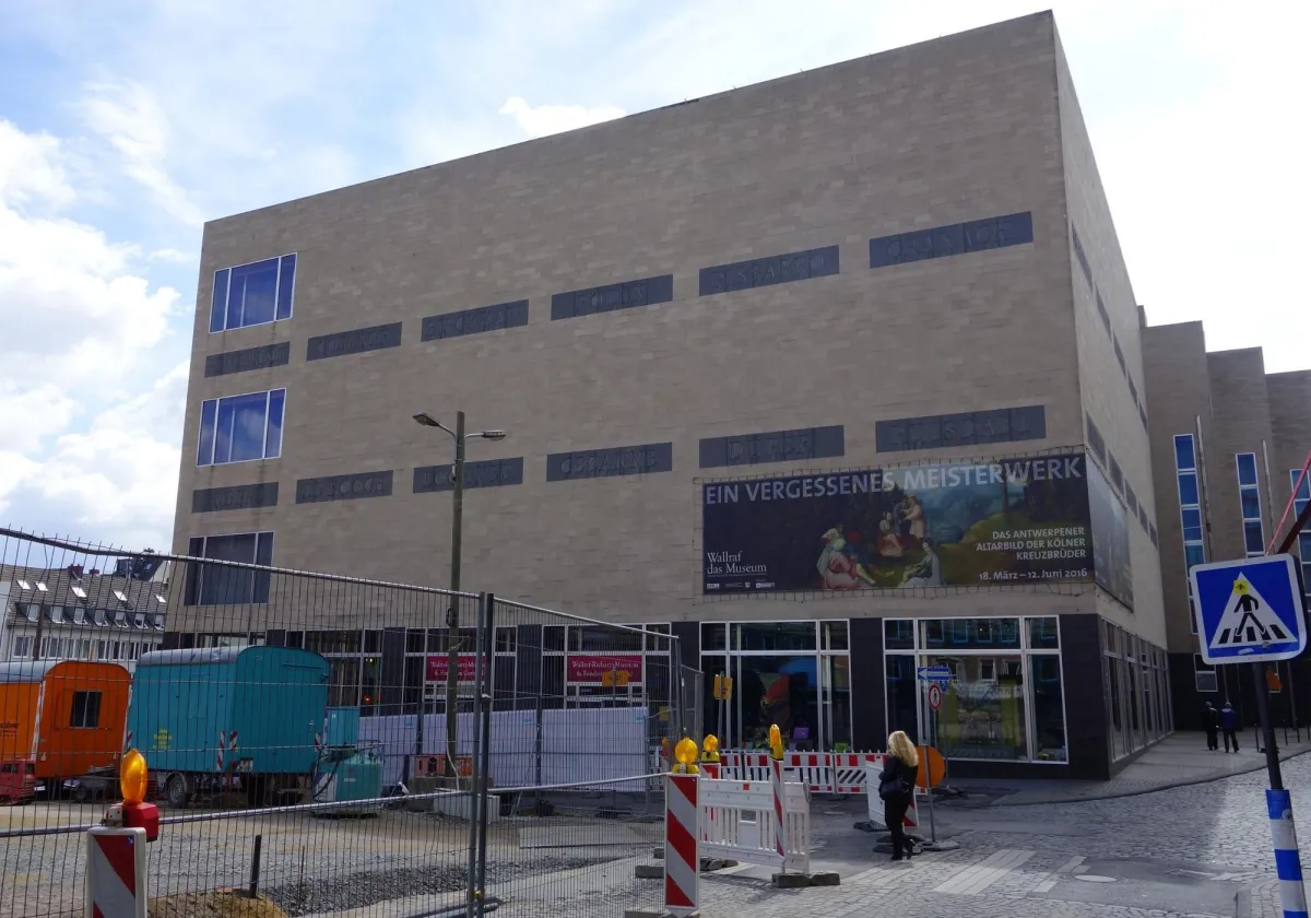 Gebäude mit Bauzaun und Werbeplakat