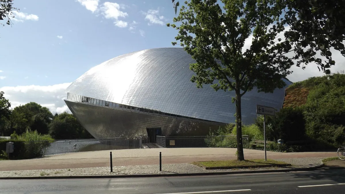 Silbernes, futuristisches Gebäude mit Bäumen