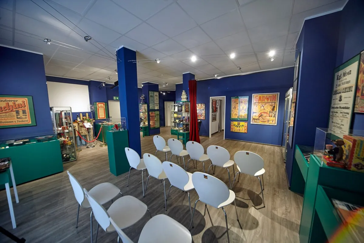 Innenansicht eines Museums mit Stühlen und Ausstellungsstücken.
