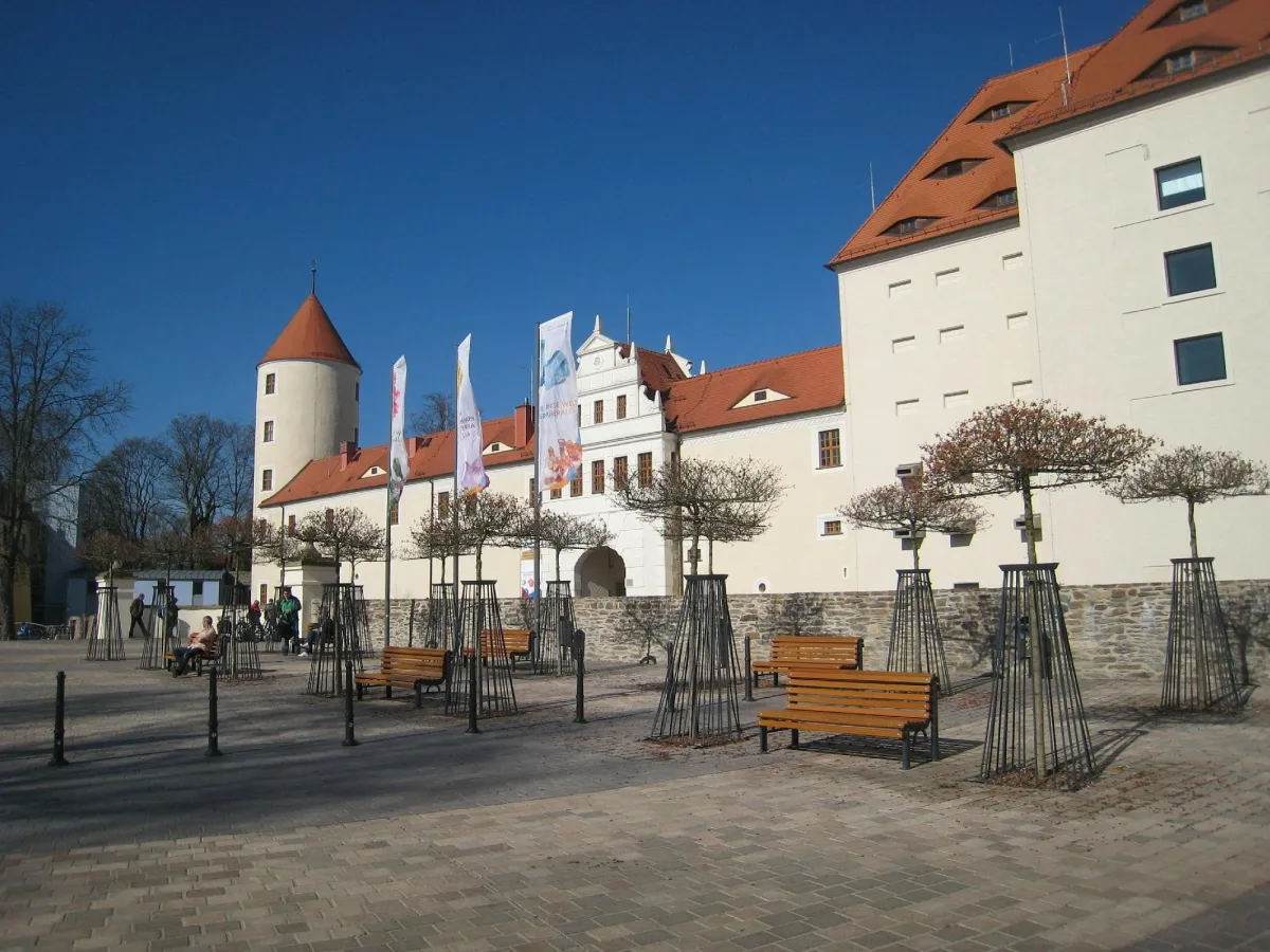 Schloss mit Türmen und Innenhof, Bänke und Bäume