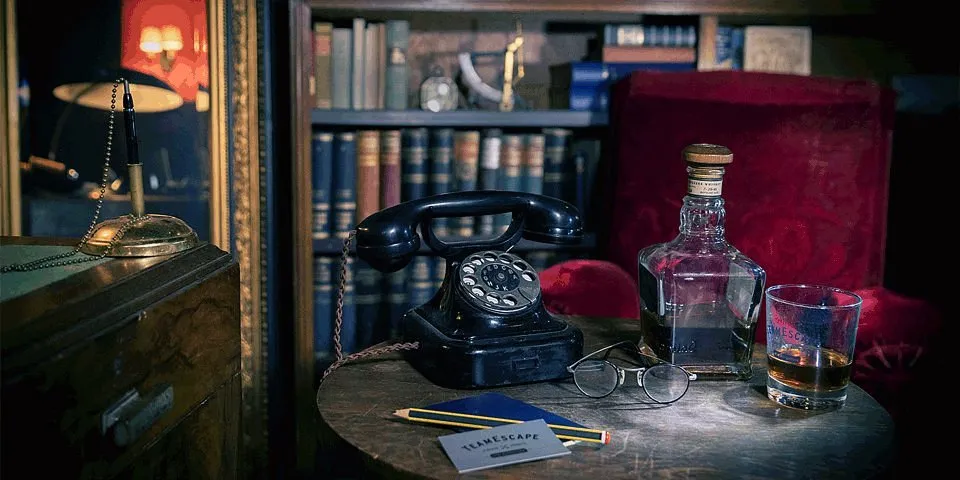Vintage Telefon, Brille, Whiskyflasche und Glas auf Tisch