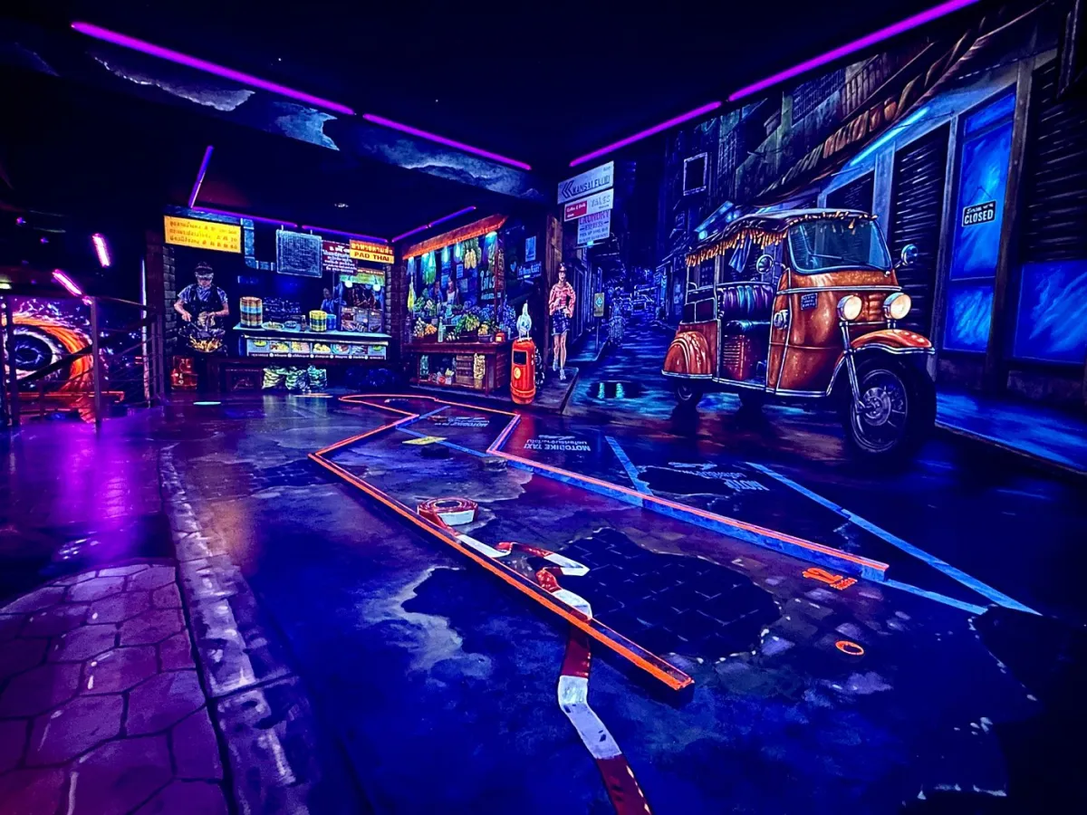 Neonbeleuchtetes Indoor-Minigolf mit Wandmalerei.