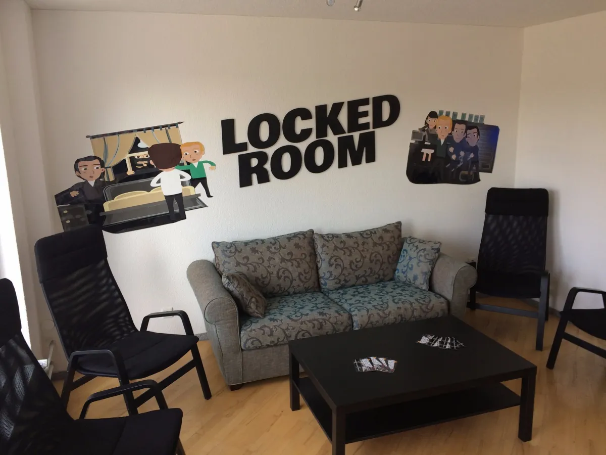 Sofa und Stühle in einem Raum mit 'Locked Room' Schriftzug.