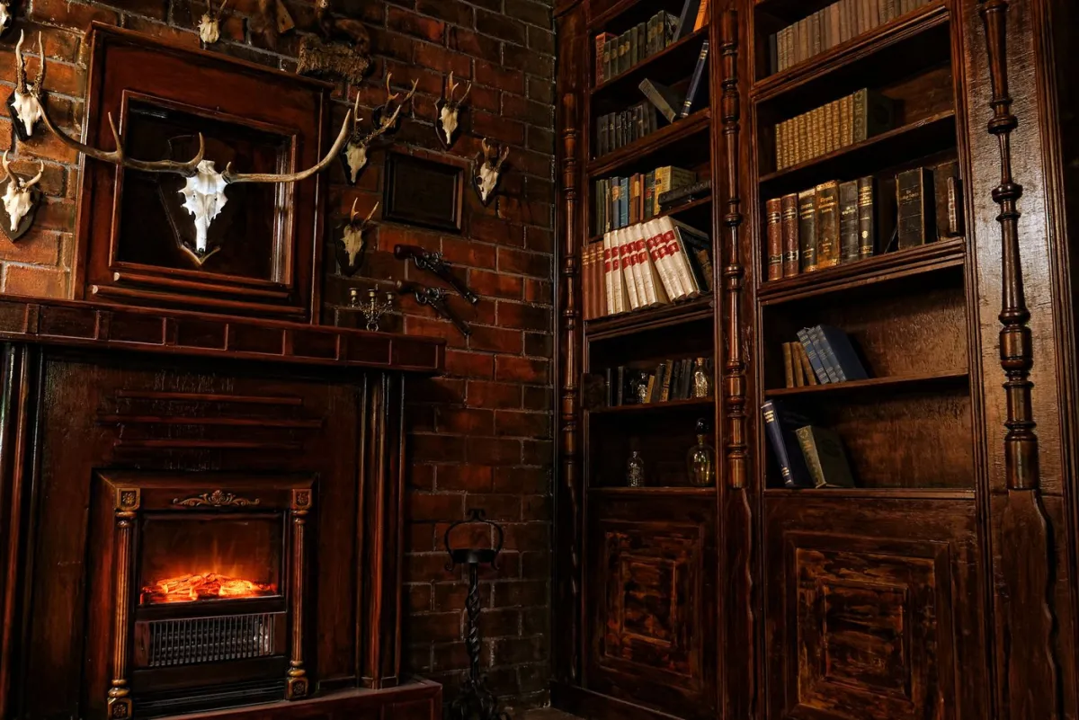 Gemütliches Kaminzimmer mit Bücherregal und Geweihen