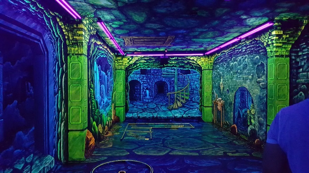 Leuchtender Raum mit Neonfarben und Wandmalereien.