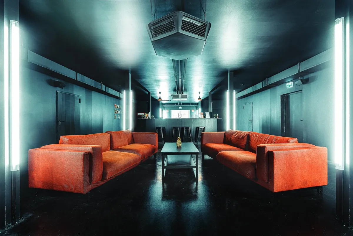 Lounge mit roten Sofas und Bar im Hintergrund