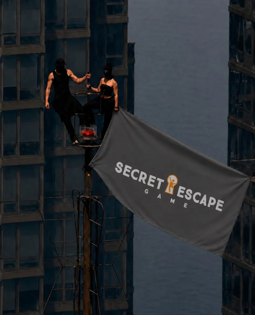 Zwei Personen auf einem hohen Turm mit einem Banner.