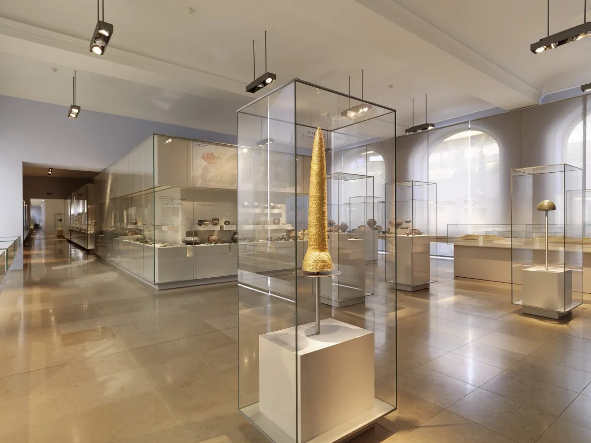 Museumsausstellung mit goldener Kegelskulptur