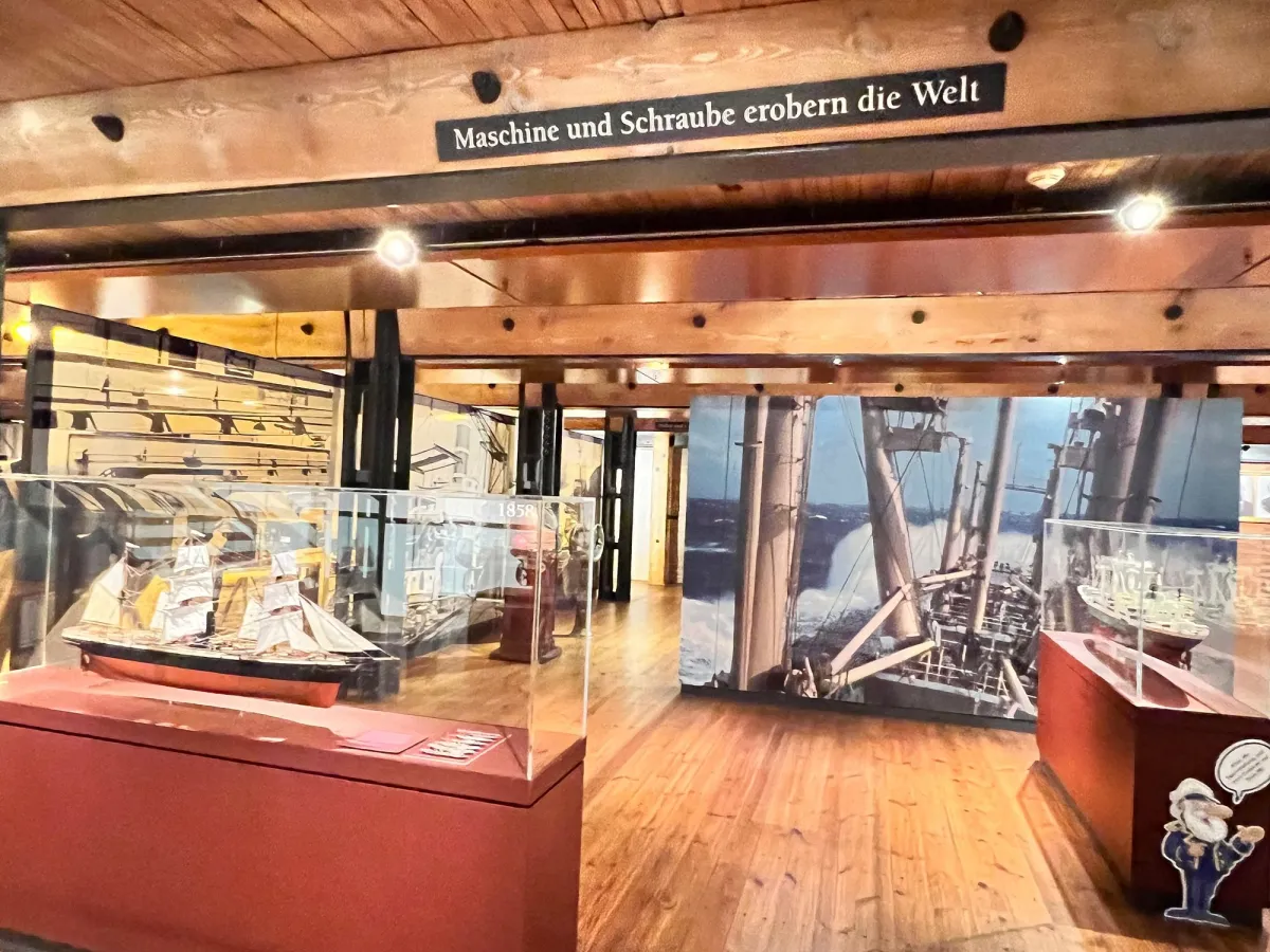 Ausstellung mit Schiffsmodell und historischem Bild.