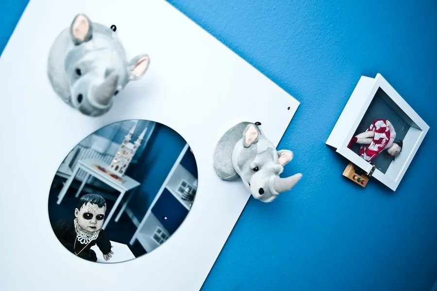 Wanddekoration mit Rhinozerosköpfen und Bild.