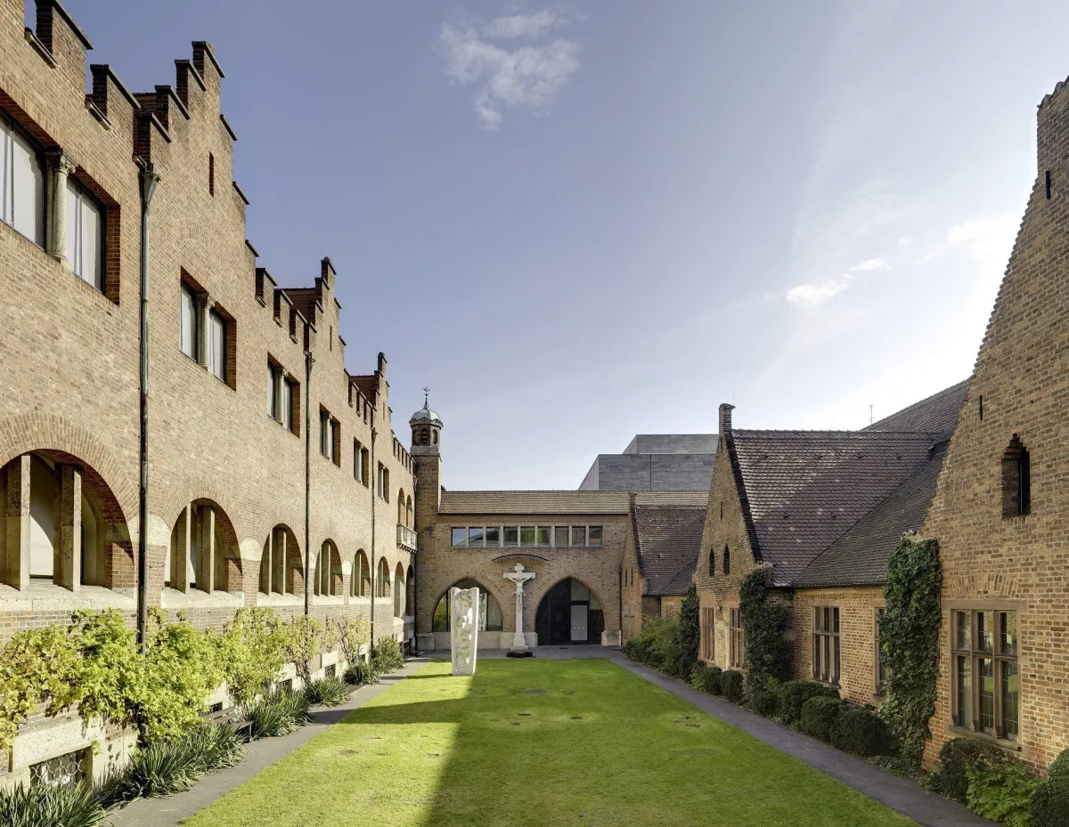 Historischer Innenhof mit Backsteingebäuden und Rasen.