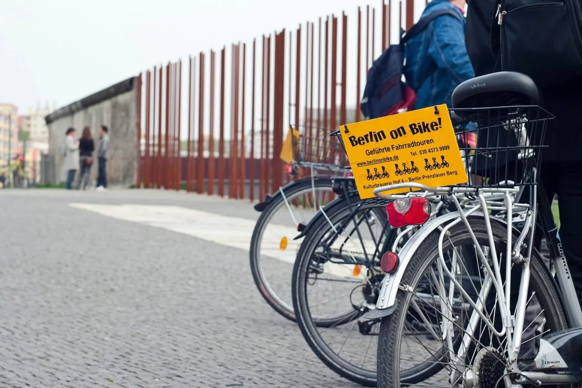 Fahrräder mit Schild 'Berlin on Bike' an einem Zaun