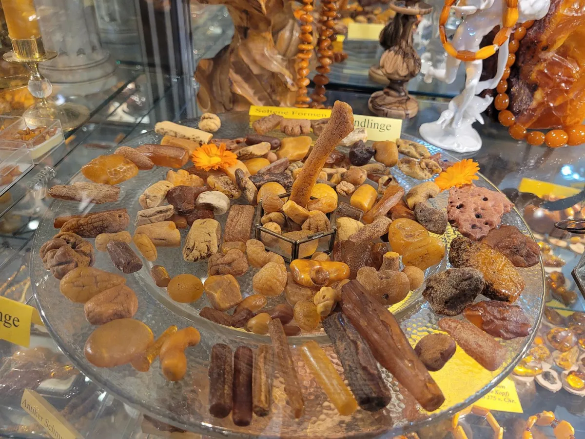 Verschiedene Bernsteinstücke auf einem Glasteller.